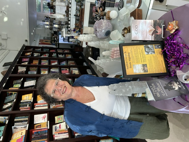Amy Glin at an author event and book signing with copies of her books