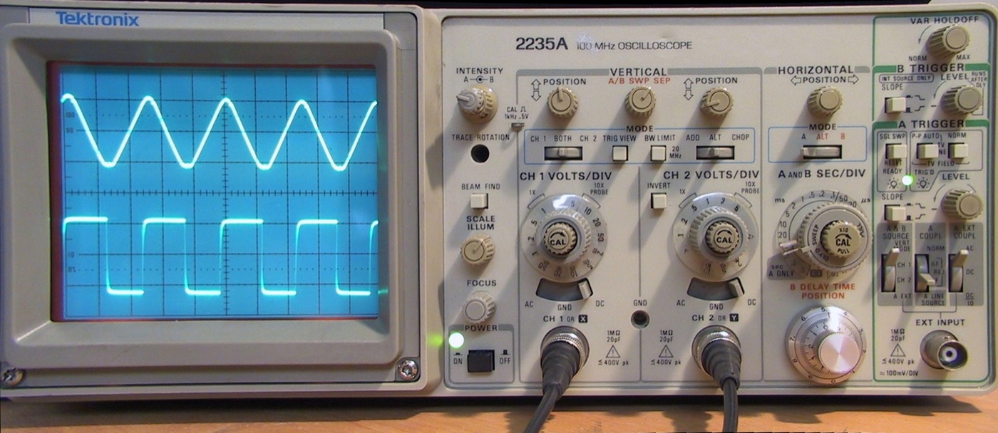 Sine and square frequency waves displayed on an oscilloscope