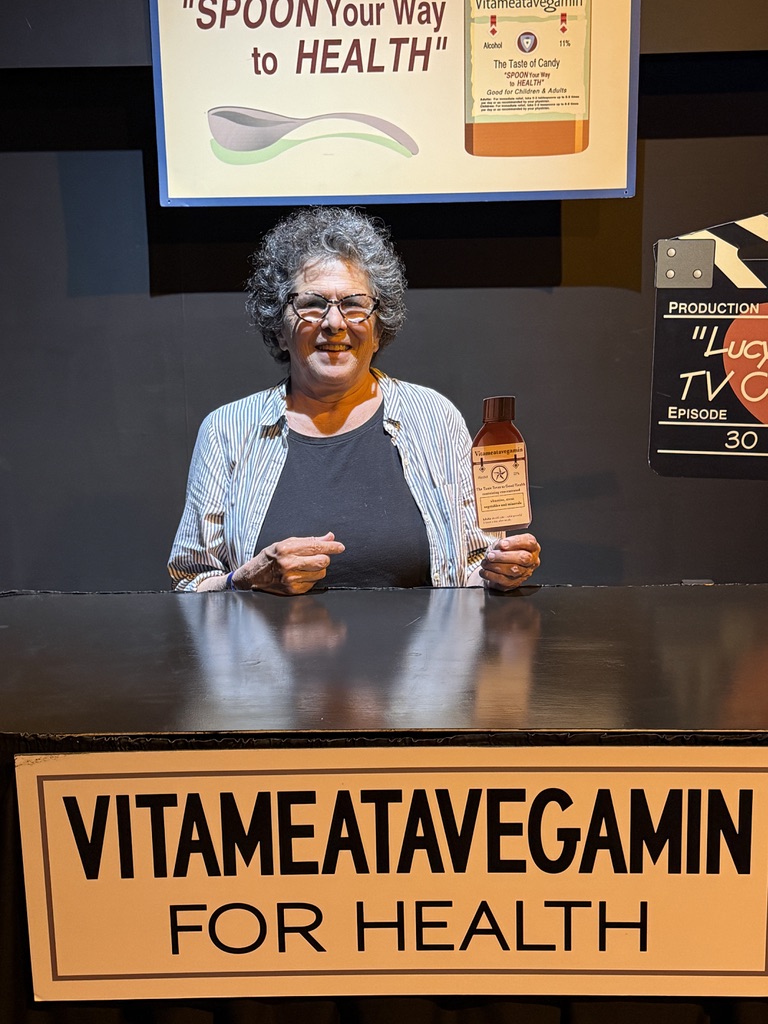 Woman holding a novelty bottle on a television set