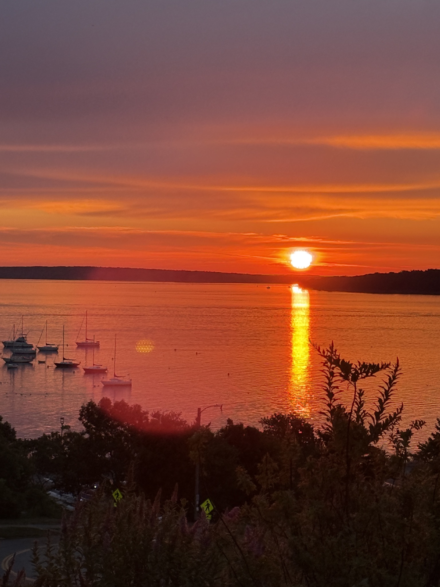 Brilliant orange sunset over boats on the water